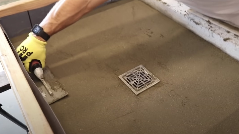 man creating sloped shower pan