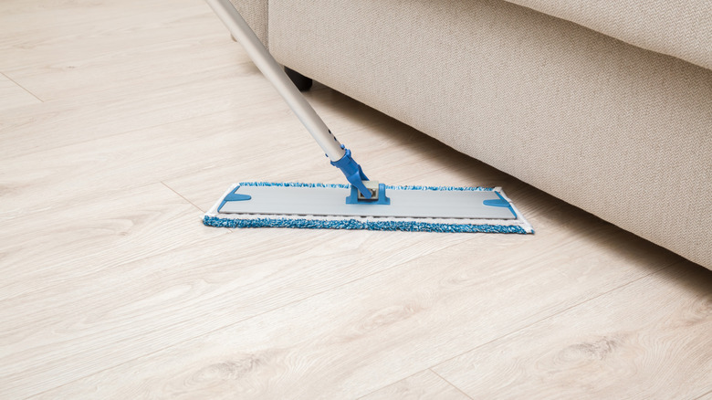 Micofiber mop sitting over beige wood floor