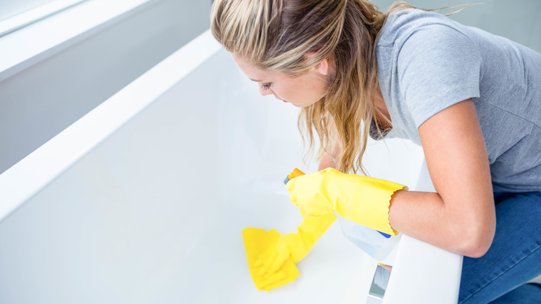 woman cleaning bathtub