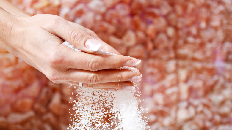 person pouring salt through hands