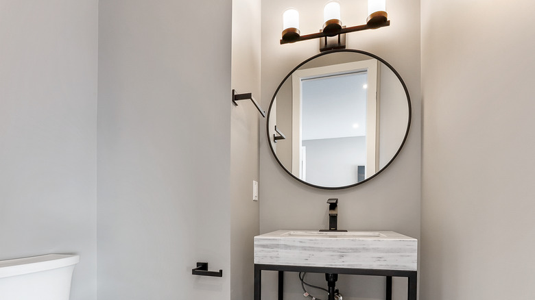 Powder room with circular mirror