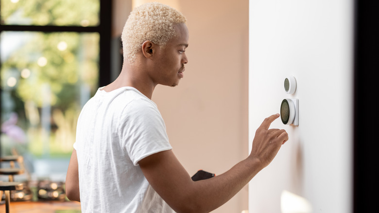 man changing thermostat