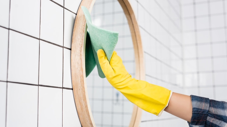 person cleaning mirror