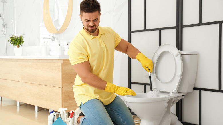 man cleaning toilet