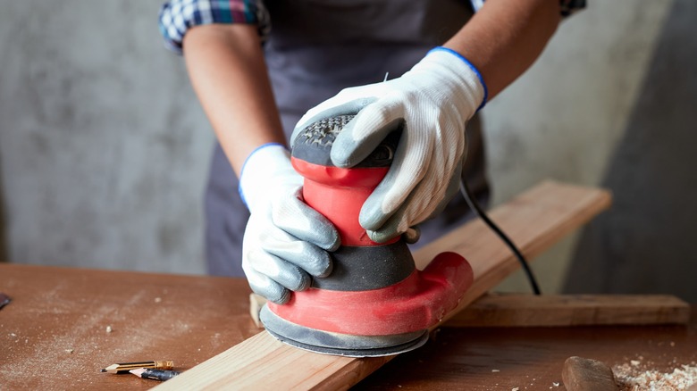 Woman using electric sander