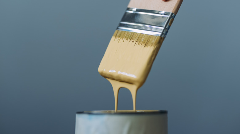 dipping paint brush in can