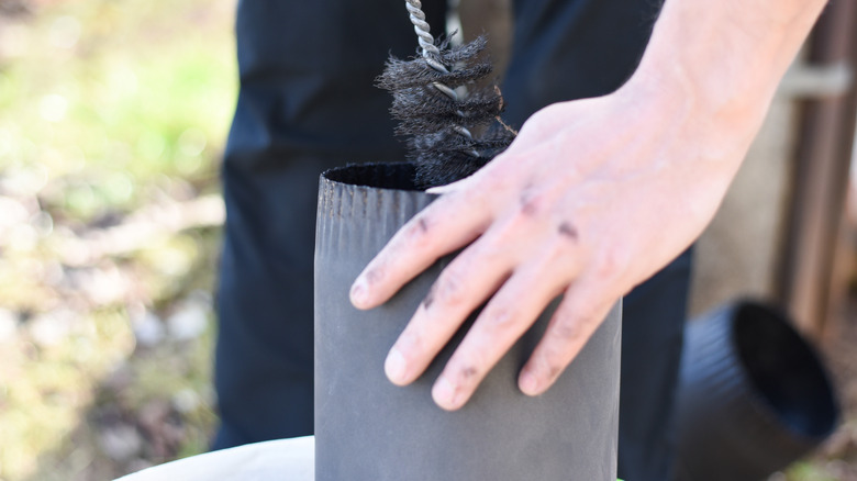 person cleaning chimney with brush