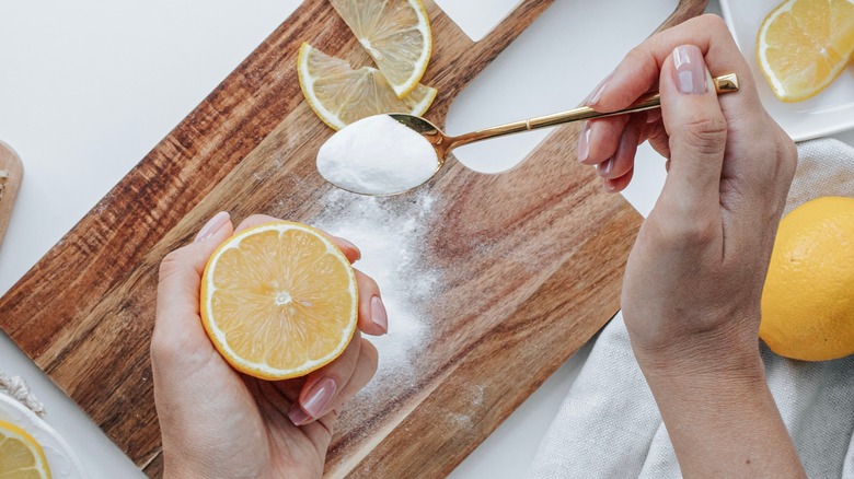 person cleaning wooden cutting board