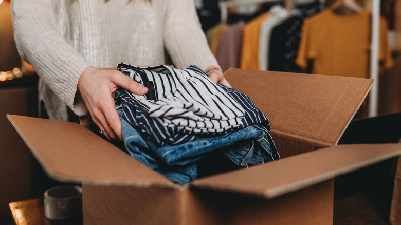 Woman placing clothes in box