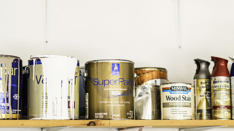 paint cans on wooden shelf