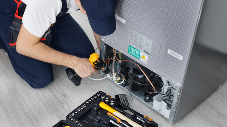 A technician repairing a fridge