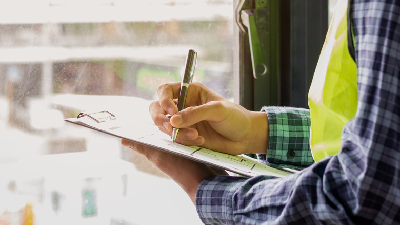 Man writing in clipboard