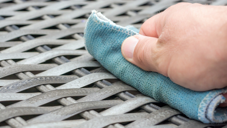 wiping wicker furniture with rag