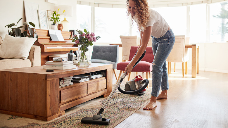 woman vacuuming a rug 