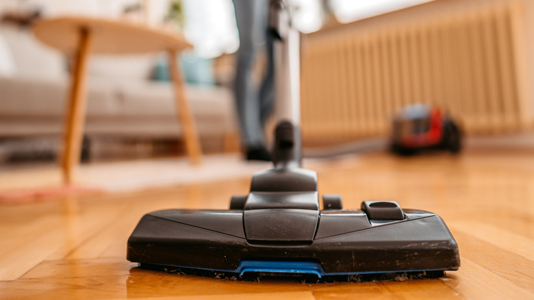 someone hoovering wooden floor 