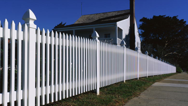 White picket fence blocking a house