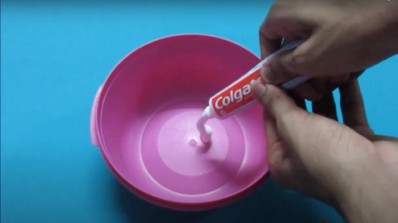 Adding toothpaste to bowl