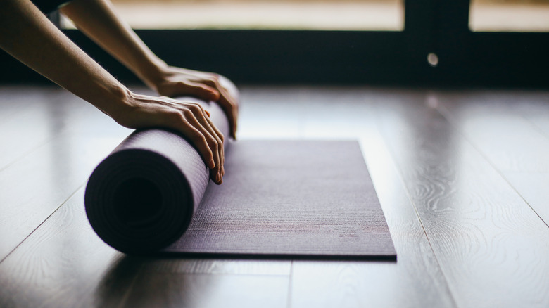 Person rolling up yoga mat