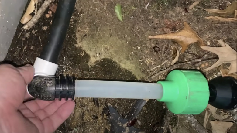 man vacuuming ac drain pipe