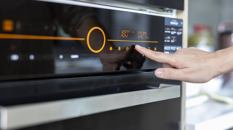 Person turning oven on