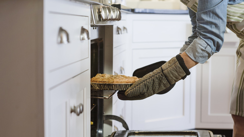 Person placing pie in oven