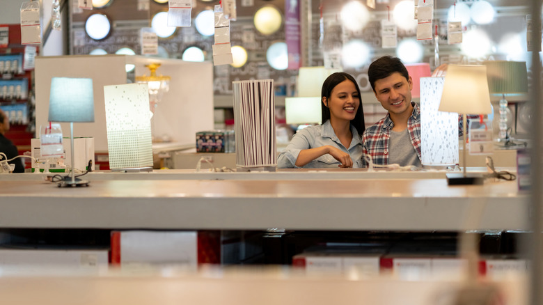 Two people in a shop choosing lamps