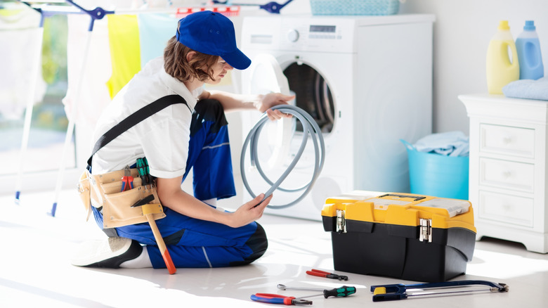 Person fixing a tumble dryer