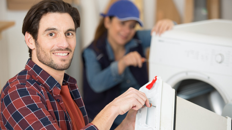 People fixing a dryer