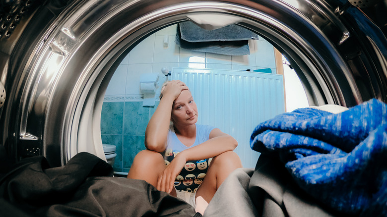 frustrated woman looking into dryer