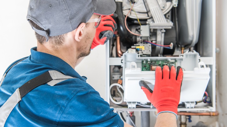 Repair technician fixing furnace