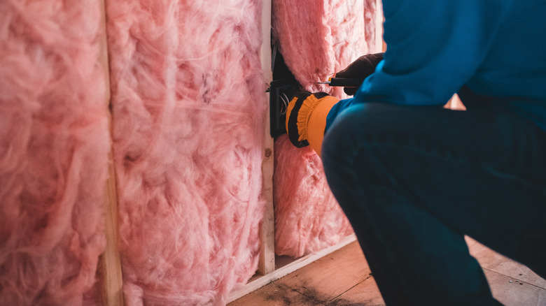 construction worker adding insulation 