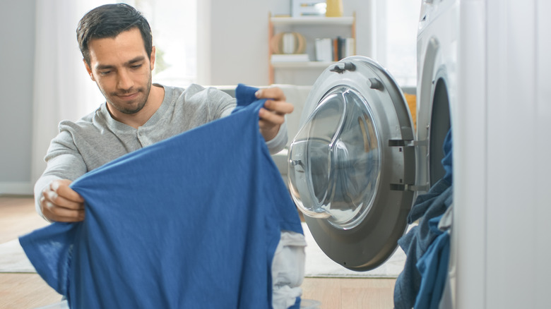 Man removing shirt from dryer 