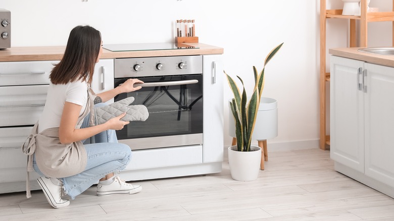 Woman holding oven handle