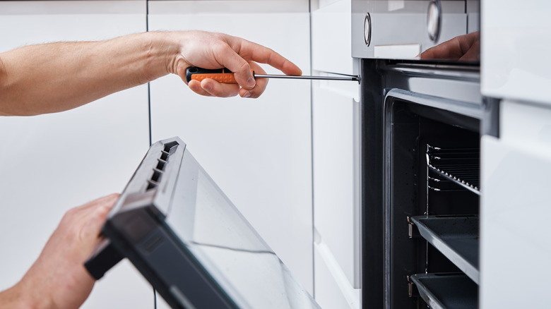 person repairing an oven