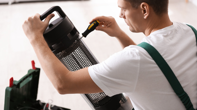 Person fixing electric patio heater