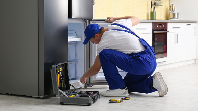 Repairman examining refrigerator