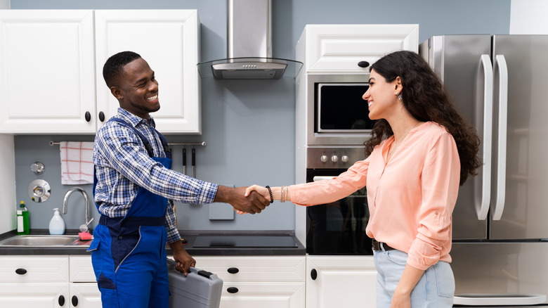 Repairman shaking hands with woman