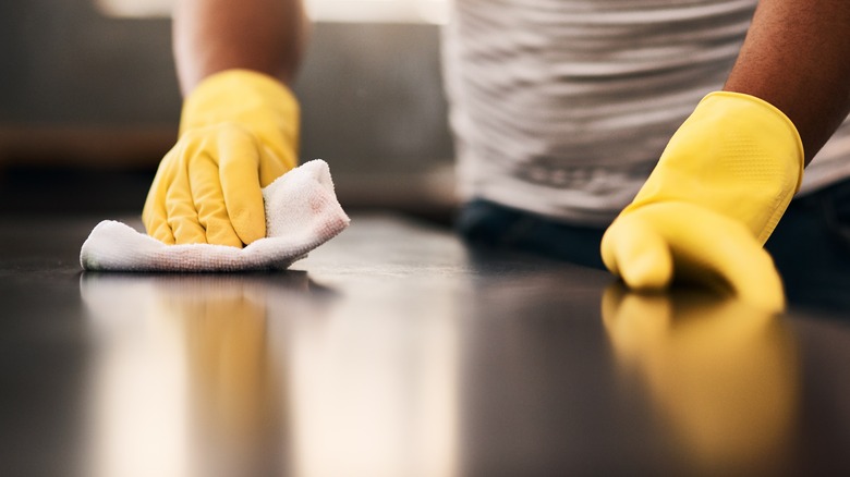 Wiping dark countertop with cloth