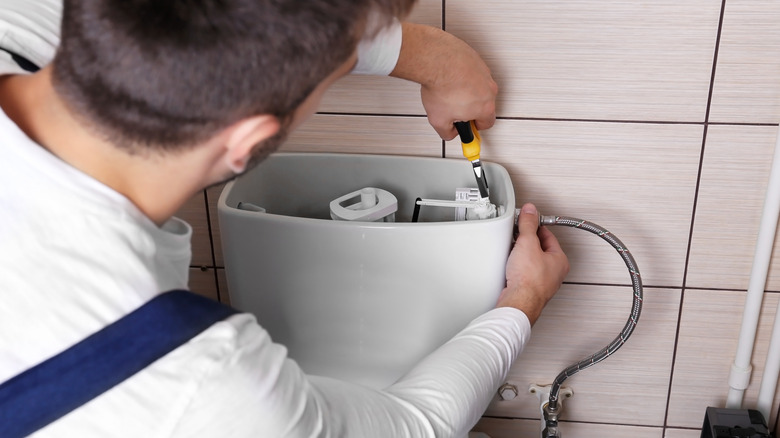 technician fixing toilet