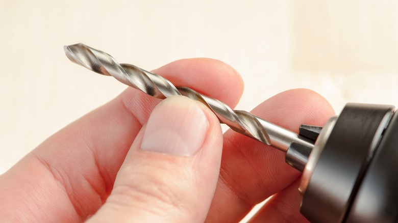 Person adjusting drill bit