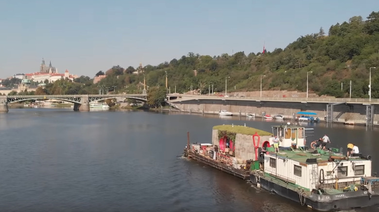 Floating barge crrying 3D-printed home in Prague