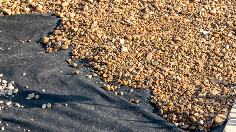 Landscape fabric placed under gravel as a weed-barrier