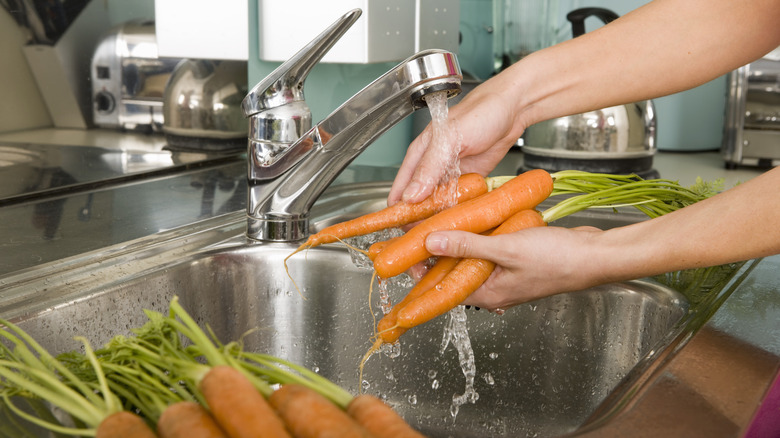 Washing carrots in sink