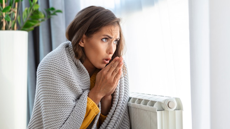 Woman sitting with a blanket cold