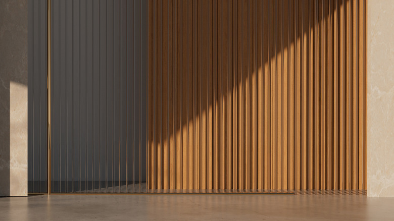 A slatted wood accent wall partly in shadow and partly in the sun