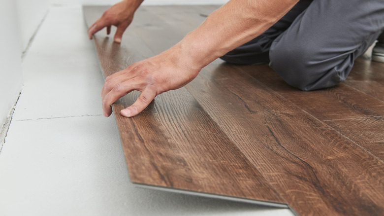 man installing vinyl flooring