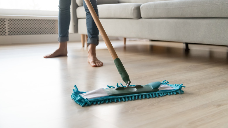 woman mopping hardwood floor barefoot