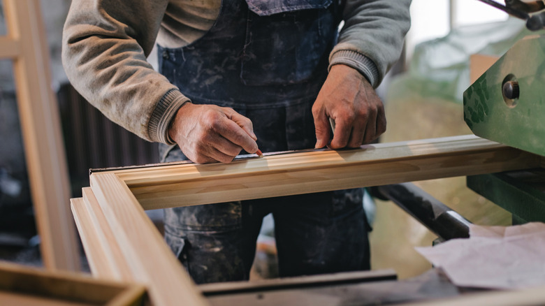 man working on wood windows