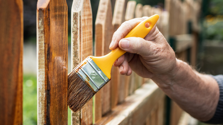 painting sealant on wood fence