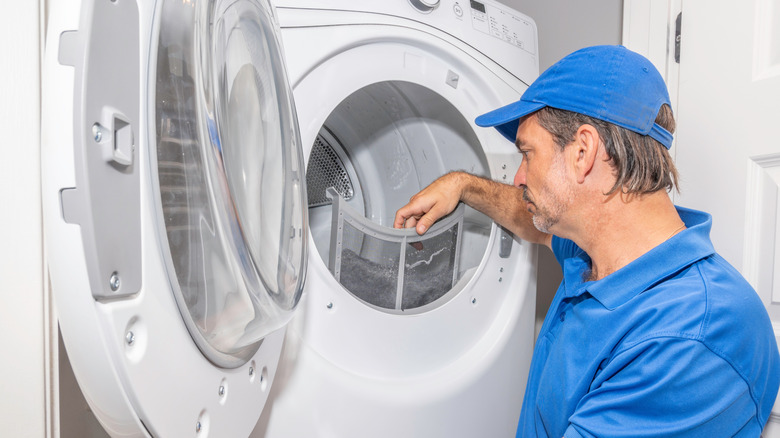 Appliance technician checking dryer lint trap